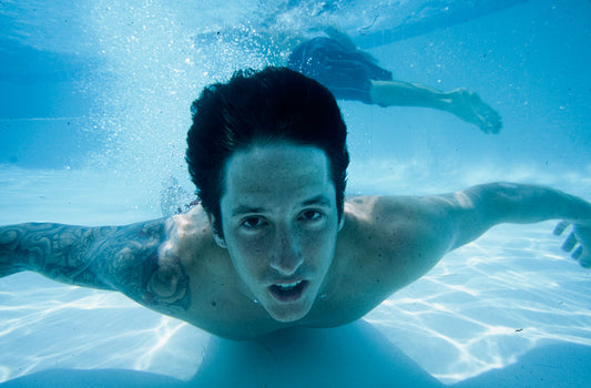 Snowboarder Romain De Marchi poses for a photo at the bottom of a swimming pool
