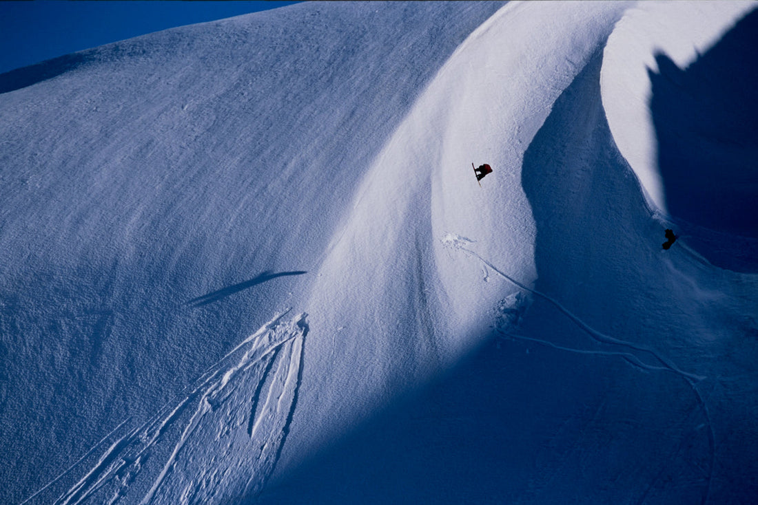 Professional snowboarder Travis Rice goes over a jump on Haines Pass